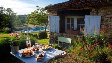table d'apéritif dans la cour du Clos Lascazes avec vue sur la piscine .