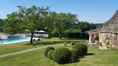 Vue sur massif de buis, le four à pain et la piscine par une belle journée d'été .